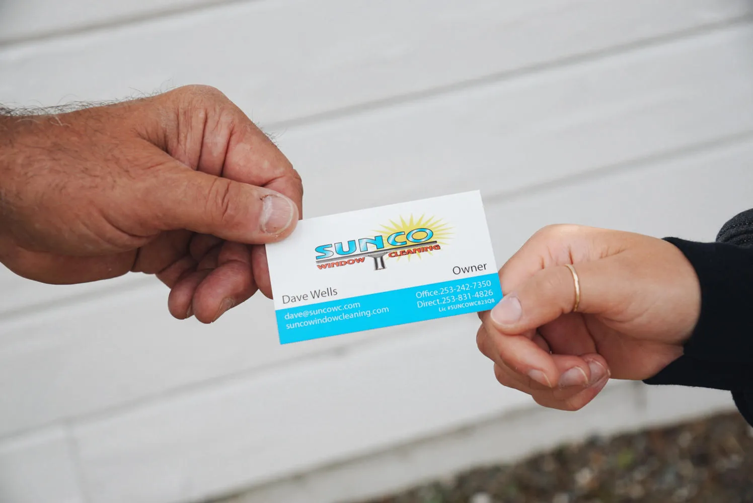 Handing over Sunco Window Cleaning business card representing owner partnership and acquisition in Edgewood WA
